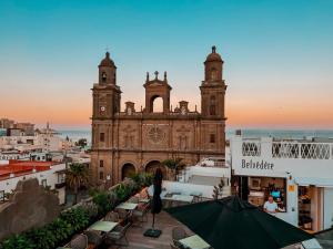 an old building with a clock tower in front of it at Boutique Hotel Cordial Plaza Mayor de Santa Ana in Las Palmas de Gran Canaria
