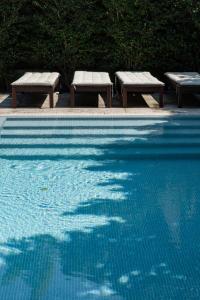 two benches sitting next to a swimming pool at Marquês Garden House by Olivia in Porto