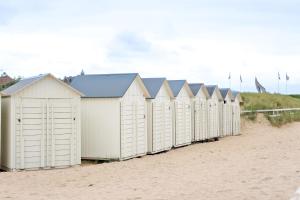 a row of beach huts on the beach at Thalazur Ouistreham - Hôtel & Spa in Ouistreham