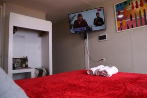 een slaapkamer met een rood bed en 2 opgerolde handdoeken bij La Belle Vue in Lima