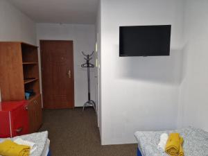 a room with a tv on a white wall at NOCLEGI WOJTEK in Bytów +24 photos