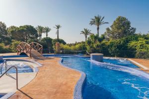 a large swimming pool with two chairs and trees at Pierre & Vacances Resort Bonavista de Bonmont in Montroig