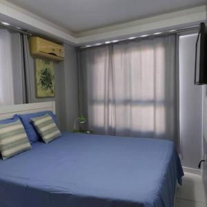 Un dormitorio con una gran cama azul con almohadas azules en Flat Atlântico Tambaú, en João Pessoa