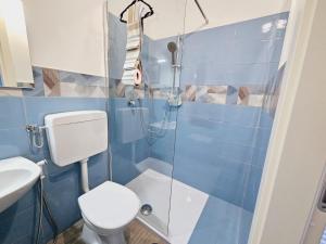 y baño de azulejos azules con aseo y ducha. en A CREMONA DA GIUSY, en Cremona