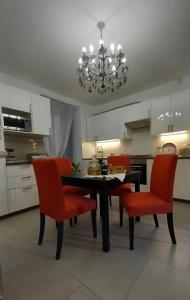 a kitchen with a dining room table and red chairs at Casa Vincenti in Orvieto