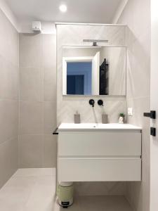 Baño blanco con lavabo y espejo en 7 SKY UDINE, en Udine