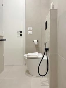 y baño blanco con aseo y ducha. en 7 SKY UDINE, en Udine