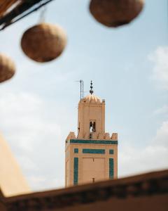 un bâtiment avec une tour d'horloge en arrière-plan dans l'établissement Riad Rafaele & SPA, à Marrakech