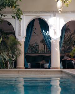 - une piscine dans une maison avec un rideau bleu dans l'établissement Riad Rafaele & SPA, à Marrakech