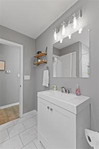 ein weißes Badezimmer mit einem Waschbecken und einem Spiegel in der Unterkunft Workfriendly home with ping pong & outdoor grill in Clarksville