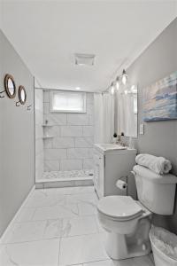 ein weißes Bad mit einem WC und einer Dusche in der Unterkunft Workfriendly home with ping pong & outdoor grill in Clarksville
