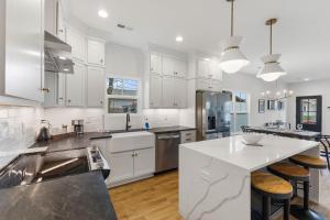 a kitchen with white cabinets and a white counter top at Sunny & modern Derby house in Jeffersonville