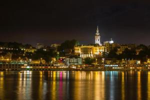 uma cidade iluminada à noite na água em Belgrade River view 1 em Belgrado