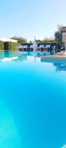 a swimming pool with blue water and a soccer ball at Trulli Nuova Aia Resort in Alberobello