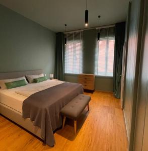 een slaapkamer met een bed, een stoel en ramen bij Ferienwohnung Hensel & Gretel in Bad Dürkheim