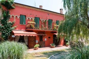 una casa roja con persianas verdes y plantas delante en Appartamento in centro storico, en San Giovanni in Marignano