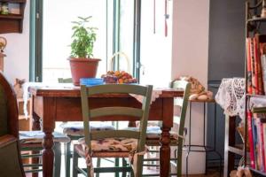 een eettafel met twee stoelen en een plant bij Appartamento in centro storico in San Giovanni in Marignano
