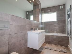 a bathroom with a white sink and a shower at 10 Quay Court in Newquay +28 photos