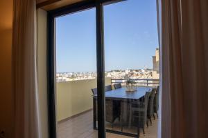 a room with a table and a balcony with a view at Miradouro da Penha in Faro
