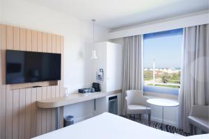 a hotel room with a bed and a tv at Thalazur Ouistreham - Hôtel & Spa in Ouistreham