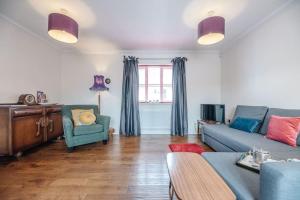 a living room with a blue couch and a chair at The Little Hopton, Saxmundham in Saxmundham