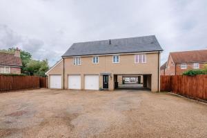 a large house with a garage and a fence at The Little Hopton, Saxmundham in Saxmundham