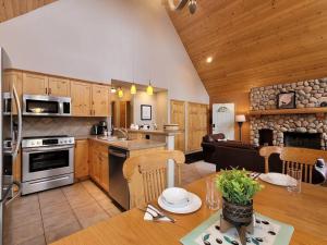 a kitchen and living room with a table and a kitchen at Pine Cone Cabin by FantasticStay in Radium Hot Springs