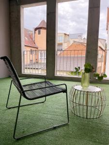 einen Stuhl und einen Tisch mit einer Vase darauf in der Unterkunft Ferienwohnung Hensel & Gretel in Bad Dürkheim