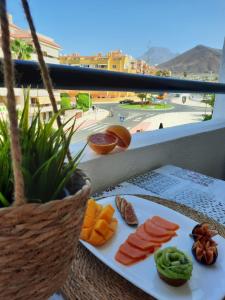 a plate of food on a balcony with a view of a street at summerland beach in Los Cristianos