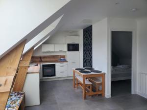 uma pequena cozinha com uma mesa e uma escada em Maison à 200m de la plage em Ploemeur