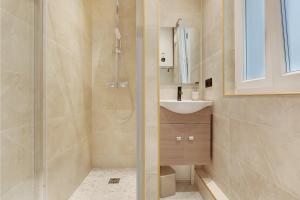 ein Bad mit einer Dusche und einem Waschbecken in der Unterkunft Cosy Appartement Portes de Paris in Aubervilliers