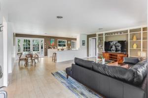 a living room with a black couch and a table at Naples LaStrada - Private pool, 12 mins to beach in Naples