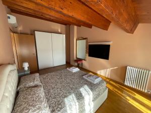 1 dormitorio con cama, espejo y TV en Appartamento Luce-- 2 camere da letto--Centro storico--Parcheggio privato gratuito, en Lugo