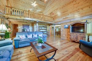 uma sala de estar com um sofá azul e uma mesa em Secluded Broken Bow Cabin with Firepit and Deck! em Broken Bow