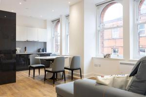 een keuken en een woonkamer met een tafel en stoelen bij Superb 2BD apartment in China Town in Manchester