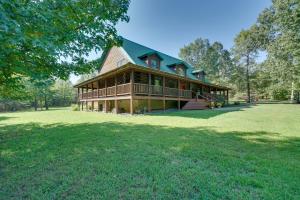 uma casa grande num campo relvado com árvores em Secluded Broken Bow Cabin with Firepit and Deck! em Broken Bow