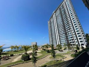 a large apartment building with a park in front of it at LW Suite at JQ Seaview 2BR High Floor & Wi-Fi in Kota Kinabalu
