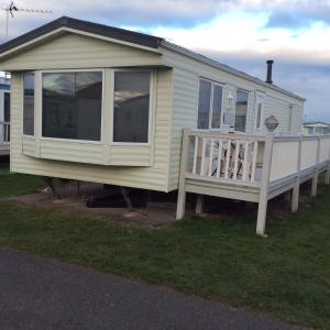 a mobile home with a porch and a deck at 2 Bedroom 6 Birth Caravan - Towyn in Abergele