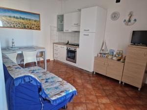 a small kitchen with a table and a kitchen with a stove at Le Residenze Blu Sardinia in La Caletta