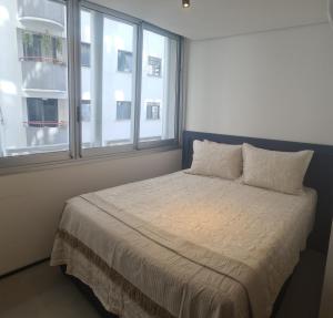 a bedroom with a bed with two pillows and a window at VN Frei Caneca in São Paulo