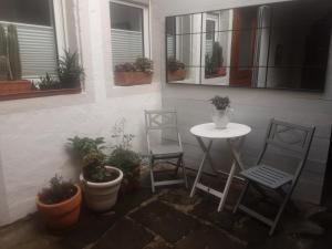patio z 2 krzesłami i stołem oraz roślinami w obiekcie Ferienhäuschen am Heumarkt w mieście Deidesheim