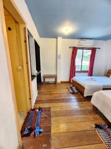 1 dormitorio con 2 camas y suelo de madera en Sweet Jungle Bungalows, en Koh Rong