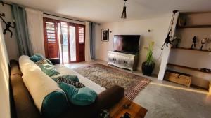 Kite & Sol Beach House Taiba في تايبا: غرفة معيشة مع أريكة وتلفزيون