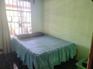 a small bed in a room with a window at POSADA VERDE 