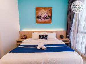 a bed with a stuffed animal laying on it at D'Pristine Suites by JBcity Home in Nusajaya