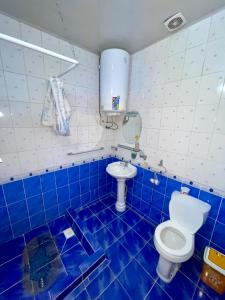 a blue and white bathroom with a toilet and a sink at Sunny Valley Karakol in Karakol