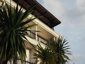 ein Gebäude mit zwei Palmen davor in der Unterkunft Yura Kiri Resort Khao Yai in Mu Si