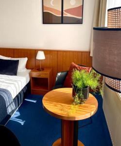 a hotel room with a bed and a table with a chair at Garni Hotel Gartenstadt Erfurt in Erfurt