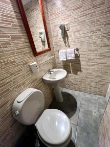 a bathroom with a toilet and a sink at HOTEL MEDITERRANEO in Montevideo