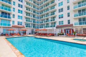 a swimming pool in front of a large apartment building at Modern 1-BD Arya Condo - Coconut Grove w-Pool & Parking in Miami